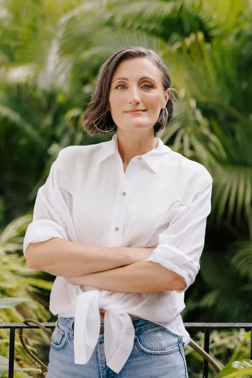 Evgenia Kostiaeva holding her camera on a Puerto Vallarta beach at golden hour
