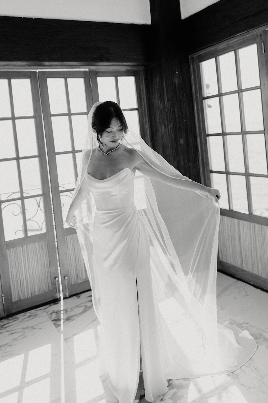 Bride getting ready in window light adjusting veil Puerto Vallarta wedding photographer