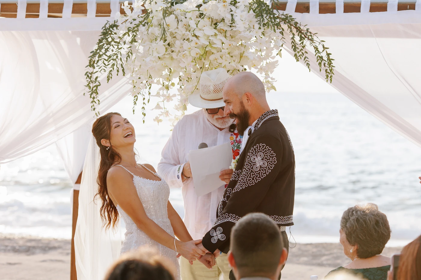 Emily and Jesse laughing during beach wedding ceremony at Villa Premiere Puerto Vallarta