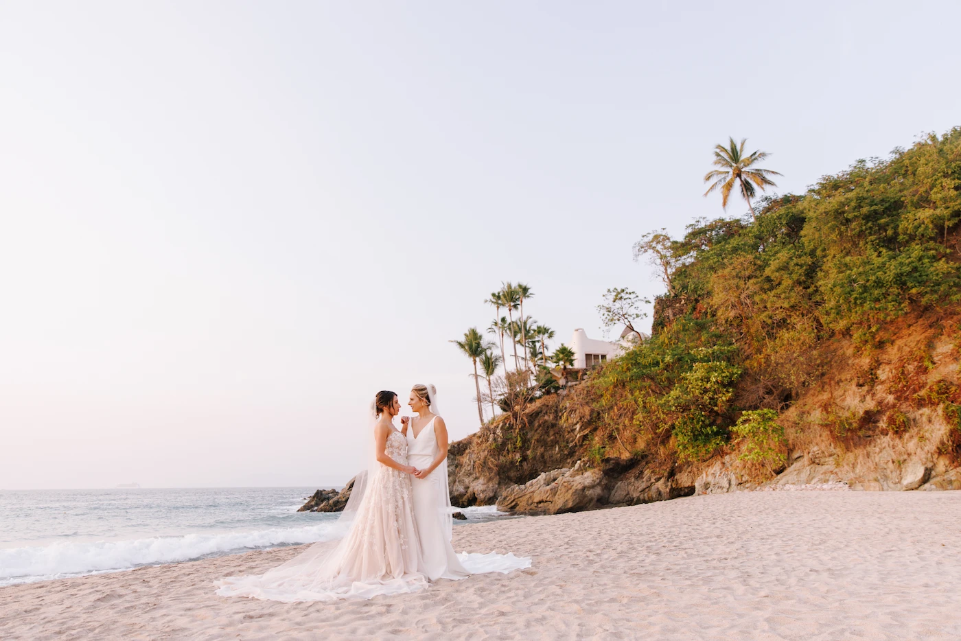 Sabina and Anne two brides holding hands on the beach at sunset Hyatt Ziva Puerto Vallarta