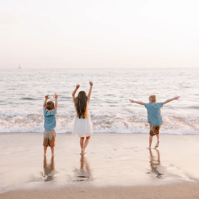 Family laughing together on the beach in Puerto Vallarta at sunset