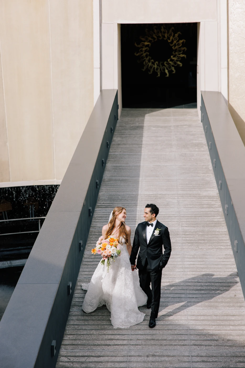 Wedding couple walking up architectural stairs at a Puerto Vallarta venue photographed by Evgenia Kostiaeva